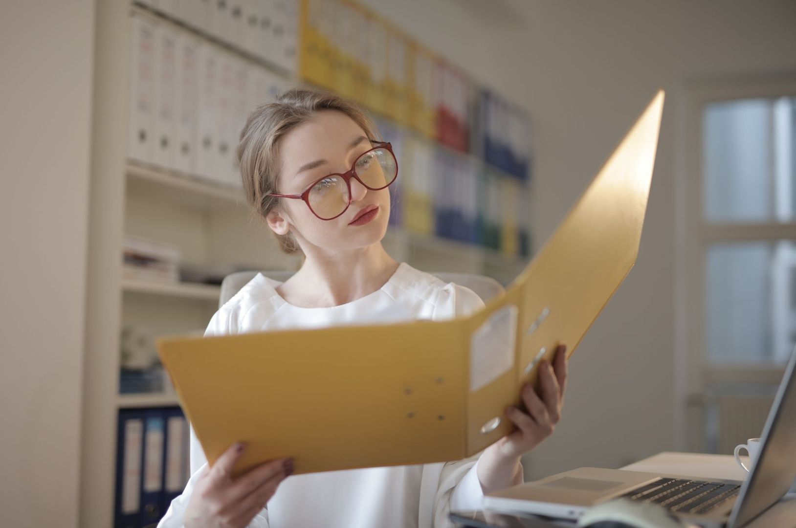 Medewerkster bekijkt een geel document in een modern kantoor