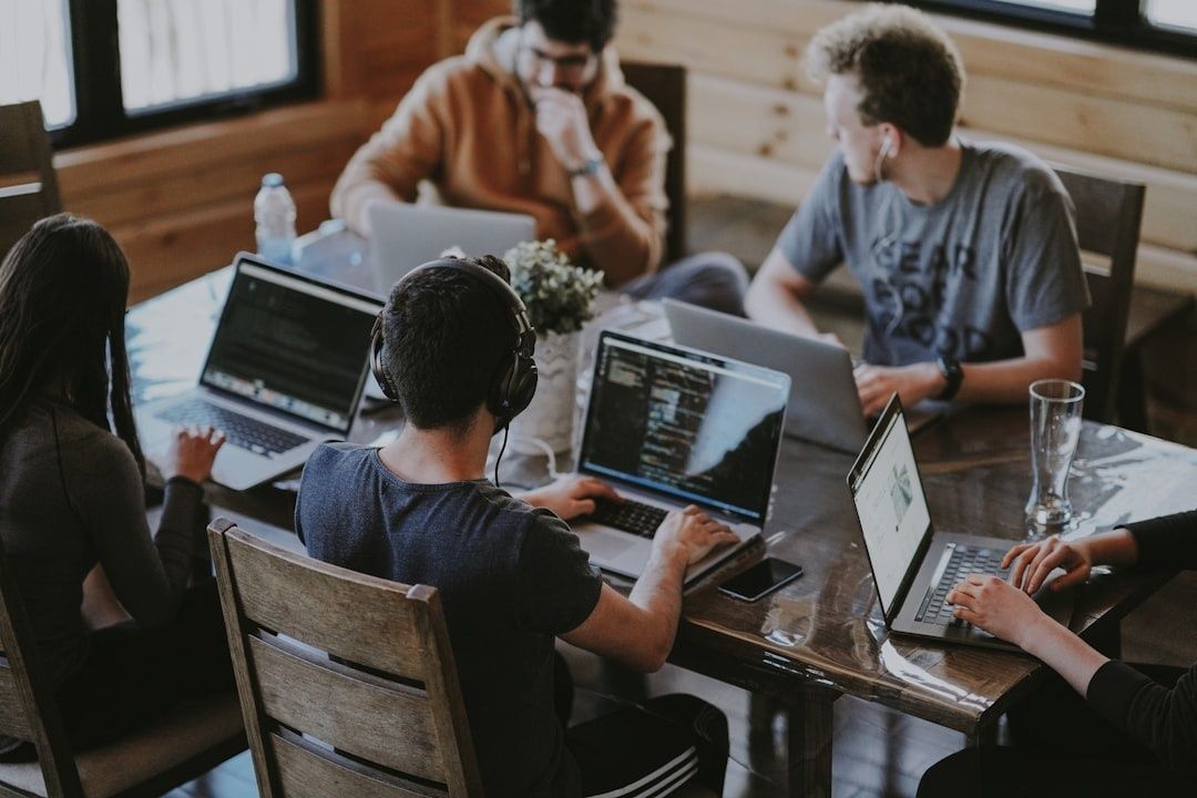 Team werkt samen aan laptops met code en documenten op tafel