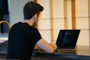 Ontwikkelaar werkt op laptop met code tijdens optimalisatie van een website